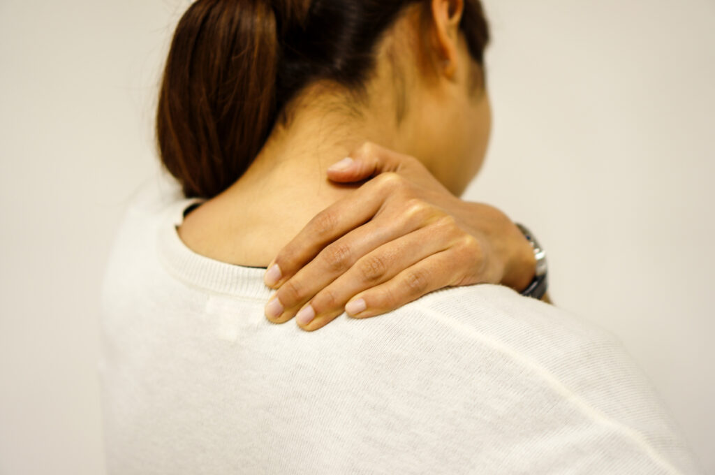 肩が凝っていて肩を押さえている女性
